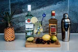 two liquor bottles near fruits